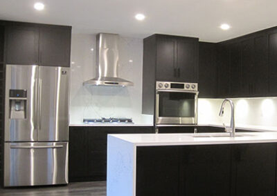 white kitchen with dark cabinets and waterfall island